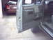 1990 Ford Bronco - The interior door panel of a 1990 Ford Bronco is visible, with a glimpse of the exterior and another vehicle in the background.