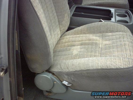Gray striped fabric car seat with a black center console and cup holders