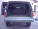 1990 Ford Bronco - Rear view of a gray Ford Bronco, revealing its spacious interior and folded rear seats.