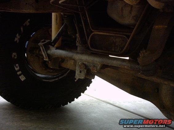 Undercarriage view showing tire with 'BIG O' text, suspension components, and exhaust pipe