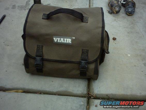 Brown canvas tool bag with VIAIR logo, next to two starter motors on concrete