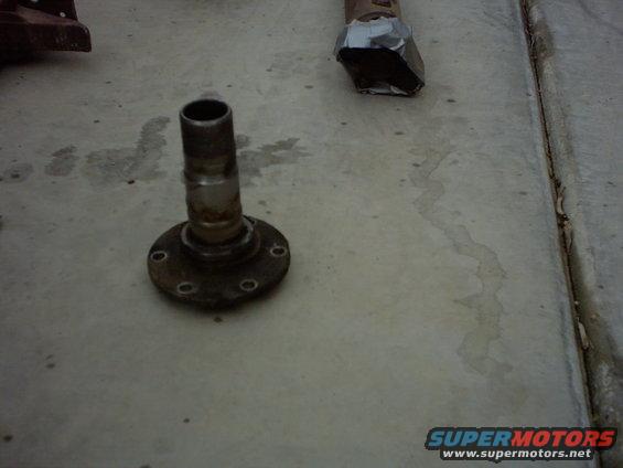 wheel hub assembly on concrete, with some metal object wrapped in tape in the background