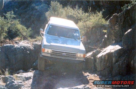 Silver Ford Bronco navigating rocky terrain