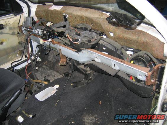 Interior of car with dashboard removed, showing wiring and steering column