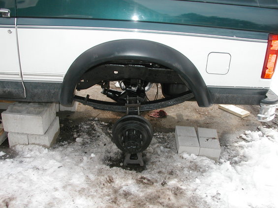 1994 Ford Bronco rear axle and leaf spring suspension, wheel removed, vehicle on jack stands