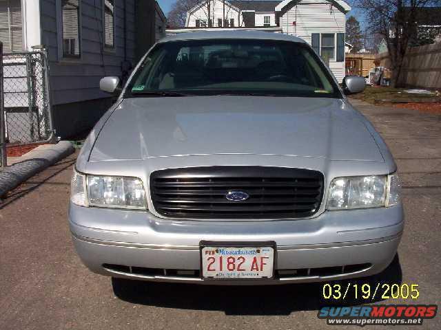 Front view of a silver 1999 Ford Crown Victoria with a black grille and Massachusetts license plate
