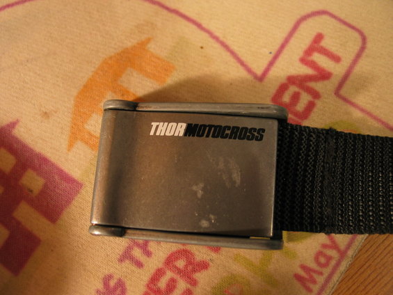 Metal buckle with black text THOR MOTOCROSS on a black nylon strap