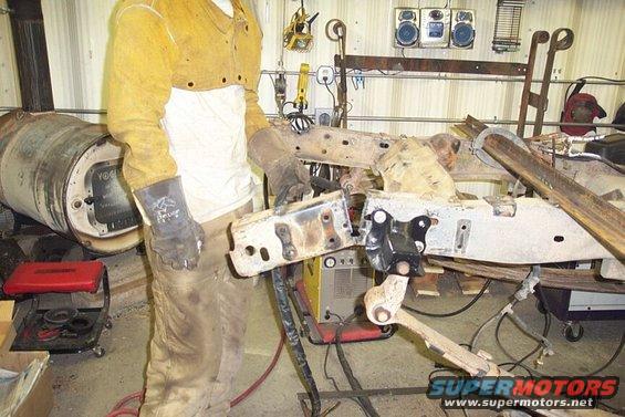 Great shot of me, huh?  I cut 10" off the rear frame.  Note the factory rear xmember has been moved forward (it's cheesy but I don't have time to build another), and I tacked angle the frame to keep it from spreading while moving the xmember.