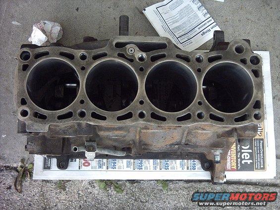 Engine block with four cylinders, resting on newspaper