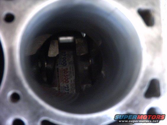 Inside an engine cylinder showing a piston with a connecting rod and a label with numbers like 30500