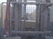 1988 Ford Bronco - A forklift is in the foreground, with a white vehicle visible in the background through a wire mesh.