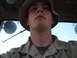 1988 Ford Bronco - A soldier wearing a camouflage uniform and hat looks upwards, with a bright sky visible in the background.