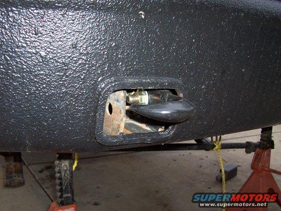 Black textured bumper with a black tow hook mounted on a bracket