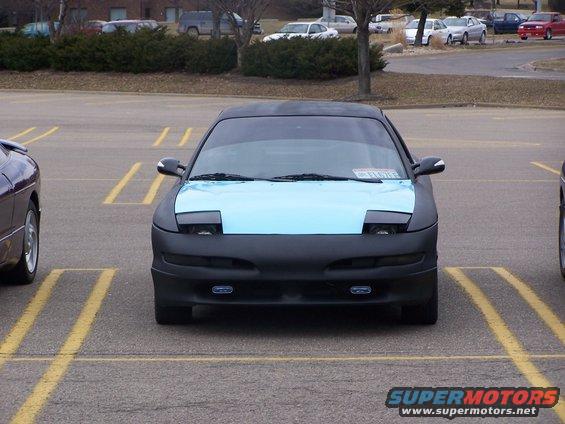 Front view of a black 1993 Ford Probe with a light blue hood and pop-up headlights