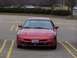 1993 Ford Probe - A red 1993 Ford Probe is parked in a lot, facing the camera directly.
