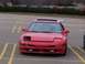 1993 Ford Probe - A red 1993 Ford Probe is parked in a lot, showing damage to its front end and a prominent rear spoiler.