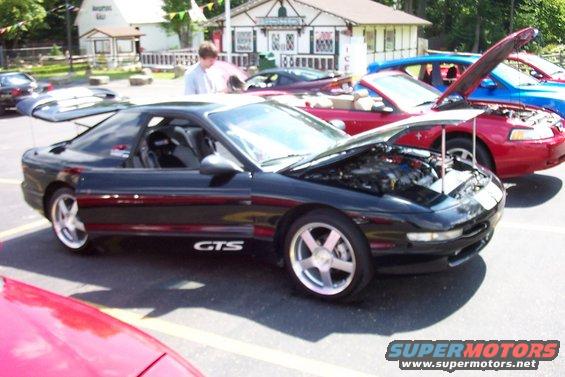 Black sports coupe with GTS badging parked in a lot with other cars