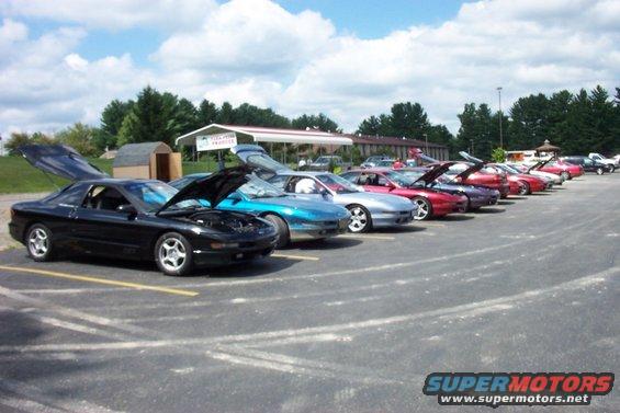 Black 1993 Ford Probe with hood and trunk open, parked in a line of similar cars