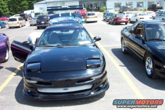 Black 1993 Ford Probe parked in a lot with its driver's door open; another black Probe is to its right