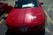 1993 Ford Probe - A red 1993 Ford Probe is parked in a lot, showing its front end and racing stripes. Another vehicle is visible to the left.
