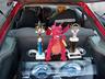 Red roll cage bars frame a trunk with two trophies and a red dragon toy