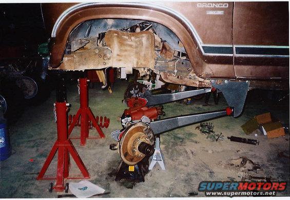 1984 Ford Bronco with front suspension removed, supported by jack stands