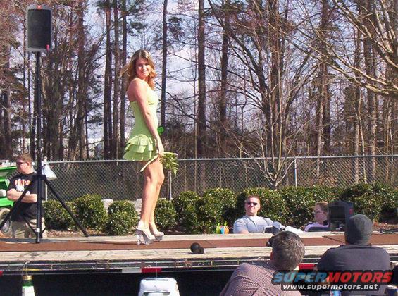 Woman in green dress on outdoor stage, audience watching