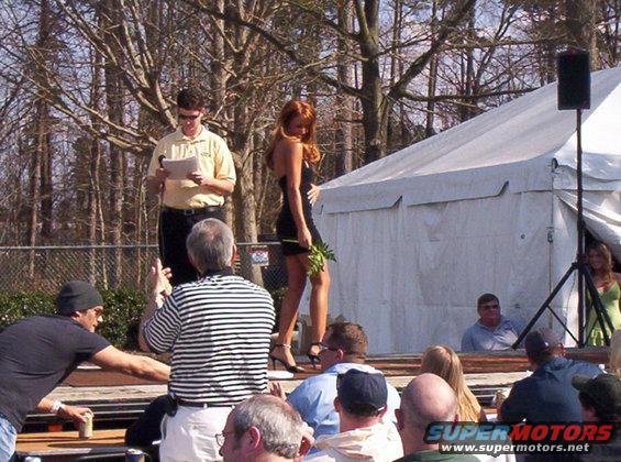 Outdoor event with people watching a woman on a stage