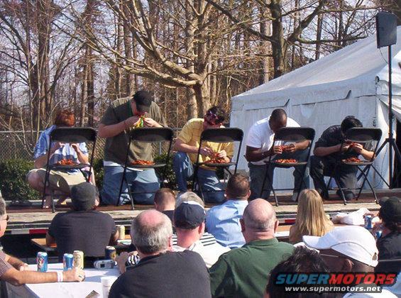 People eating at a contest with a tent in the background