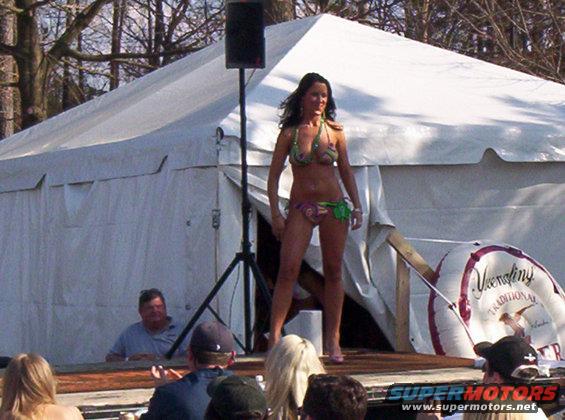 Woman in bikini on stage in front of a tent