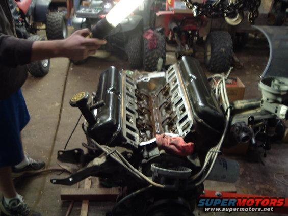V8 engine with valve covers removed, on an engine stand in a garage