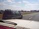 1986 Ford Bronco - A green minivan is seen driving on a highway with other vehicles in the distance.