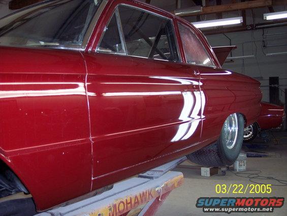 1960 Ford Falcon sedan on lift, side view. Another car visible in background