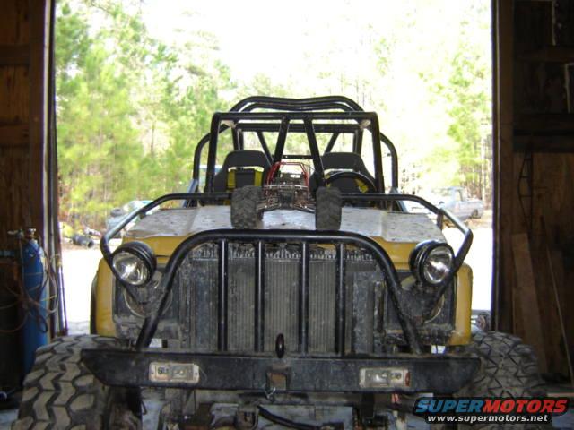 Yellow off-road vehicle front view with roll cage and large tires