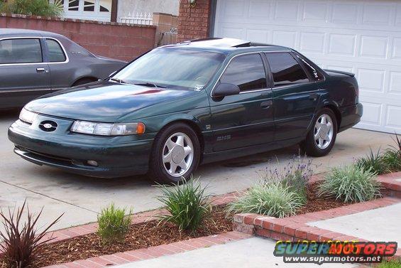 Green sedan parked in driveway, another car behind it