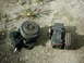 1978 Ford Bronco - Two automotive air conditioning compressors are shown resting on a gravel surface.