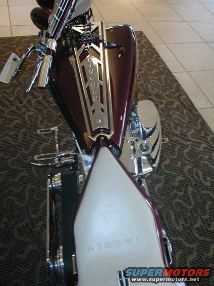Custom motorcycle with maroon tank and cream seat, "LINCOLN" text visible on tank and seat