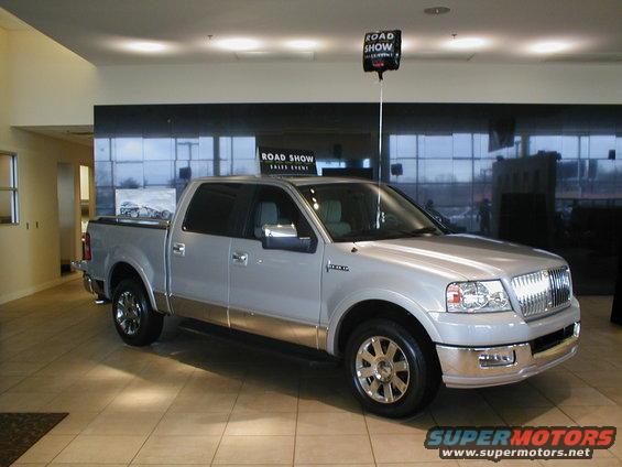Silver pickup truck with chrome accents and a "Road Show" sign above it