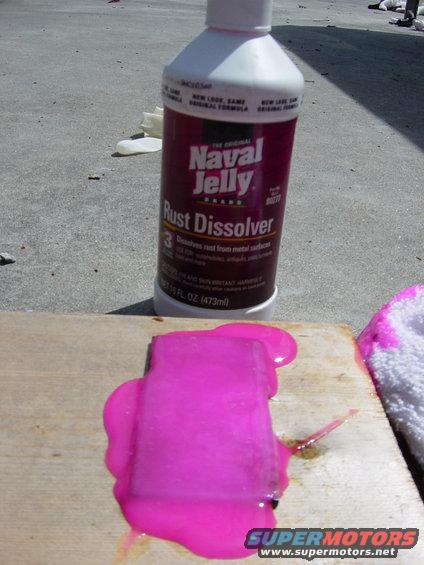 Bottle of Naval Jelly Rust Dissolver next to a piece of wood with pink gel on it