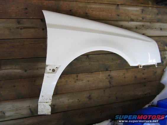 White car fender mounted on a wooden wall