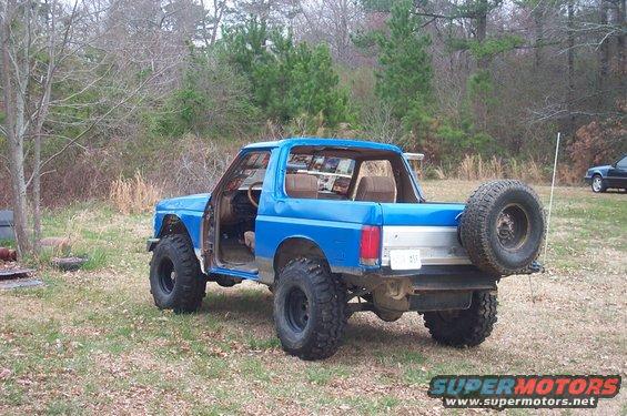 Blue 1987 Ford Bronco, rear quarter view, with spare tire mounted externally