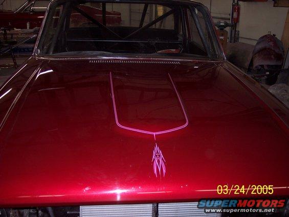Red car hood with custom pink pinstriping and roll cage visible
