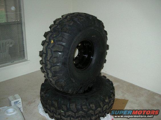Two stacked off-road tires with aggressive tread