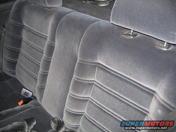 Back seat of a car with gray patterned fabric upholstery and headrests