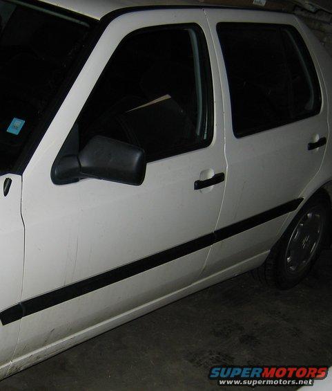 Side view of a white car showing the front door, rear door, and part of the rear wheel