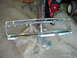 1995 Ford Bronco - A detached chrome grille is shown on a concrete surface, partially covered by plastic sheeting.