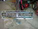1995 Ford Bronco - A chrome grille, likely for a truck or SUV, is shown lying on a concrete floor.