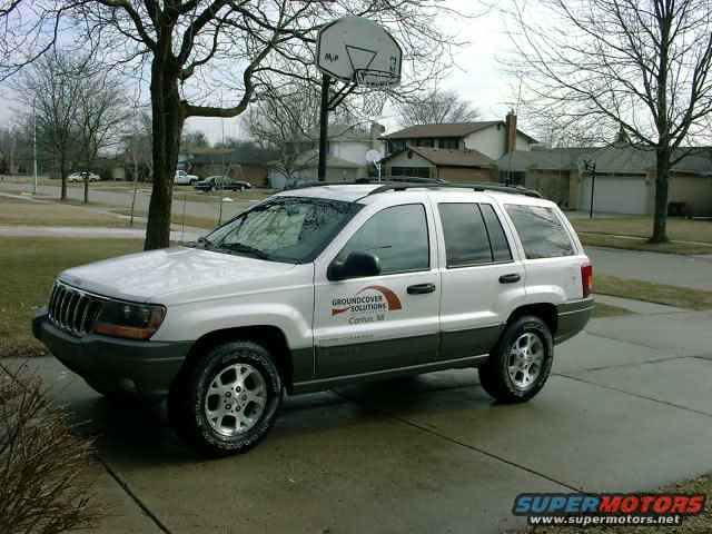 White 1999 Jeep Grand Cherokee parked on driveway, side view