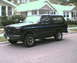 1992 Ford Bronco - A black 1992 Ford Bronco is seen from a three-quarter front view, parked on a residential street.