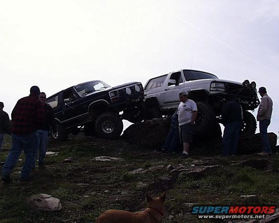1993 Ford Bronco and another lifted Bronco on rocky terrain with people around